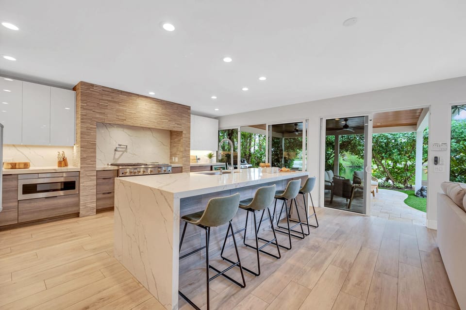 The gourmet kitchen opens on the living room featuring incredible views of the tropical landscape.