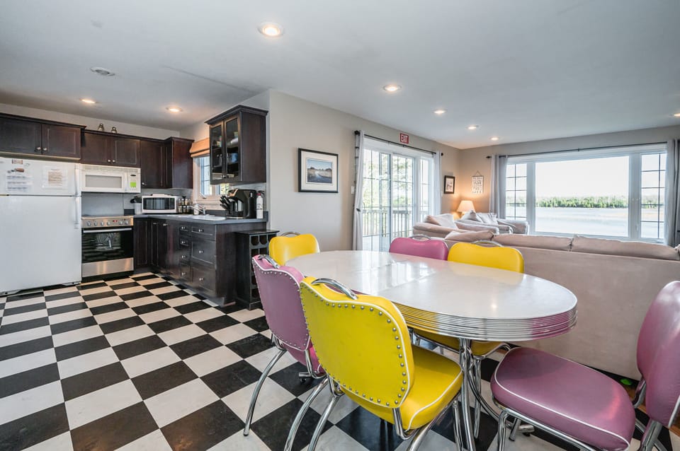 Enjoy your meals in the dining area, where retro charm meets modern chic. Pink and yellow diner-style chairs add a pop of colour, creating a lively and inviting setting for family gatherings or intimate dinners.