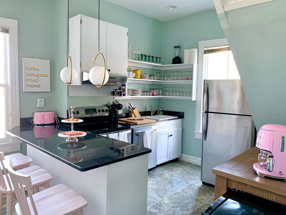 The kitchen is on the smaller side but still very functional, featuring an bar with seating, a separate coffee bar, SMEG brand 10 cup pot drip coffee maker, an additional mini fridge, microwave, toaster, blender, and all cookware/dishware