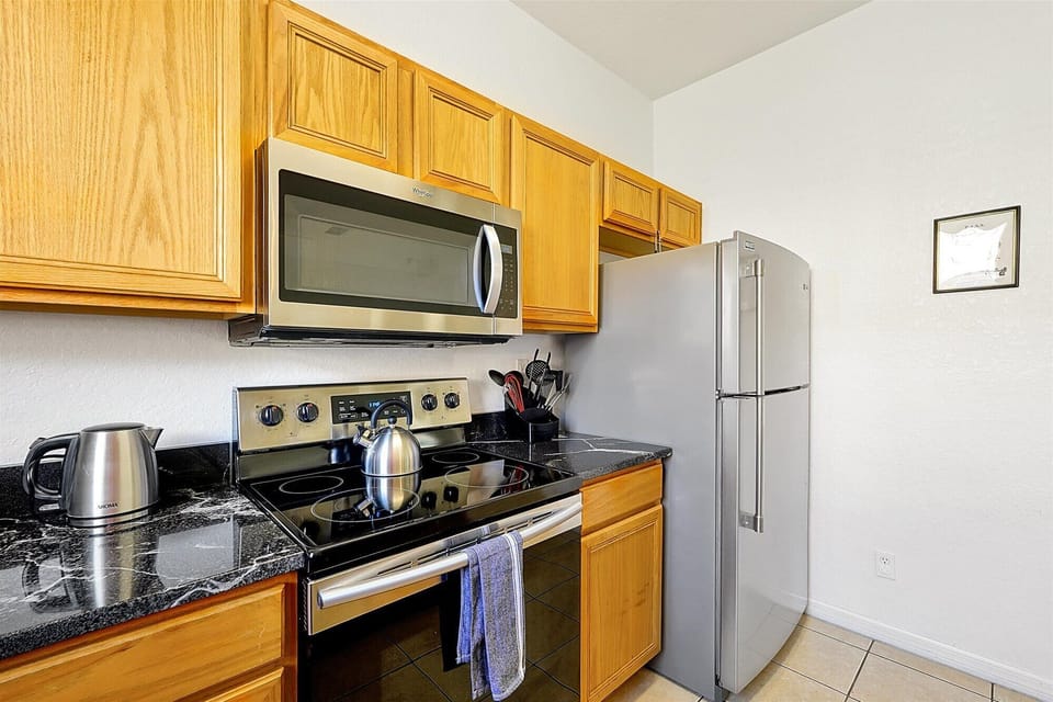 The bright kitchen is equipped with stainless steel appliances