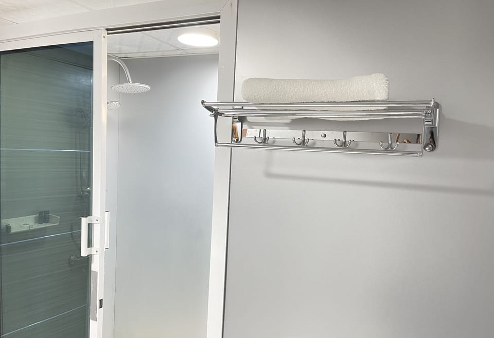 Shower, rainfall showerhead, hair dryer, towels