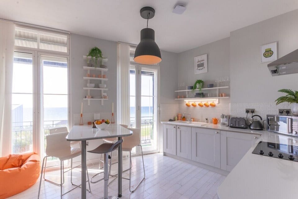 Experience culinary elegance in our bright and modern kitchen, seamlessly connected to a stylish dining area with a hint of the evening beyond.