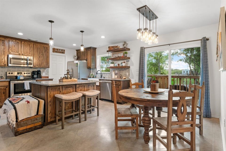 Open concept dining area. 6 chairs (4 shown) plus two counter stools