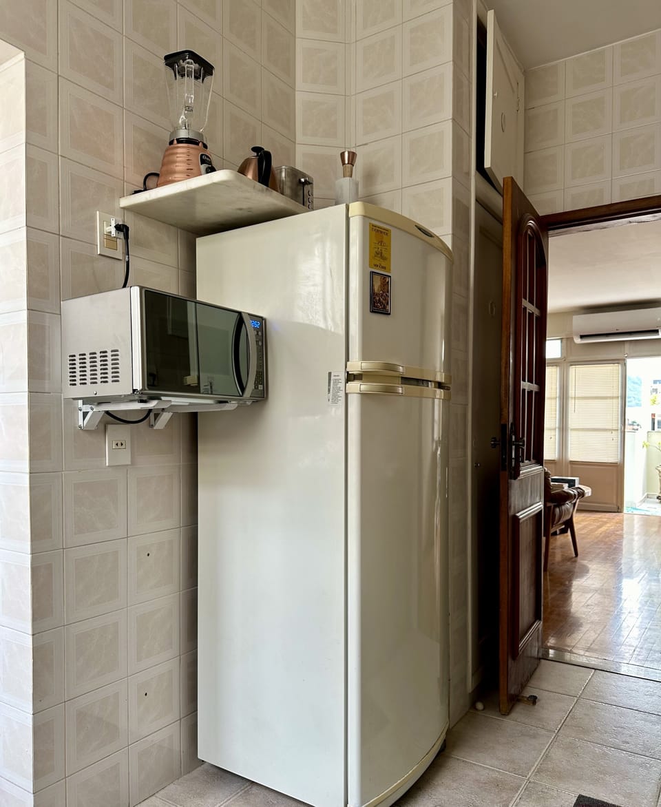 Kitchen with refrigerator, microwave, blender, and pantry with provided dishware