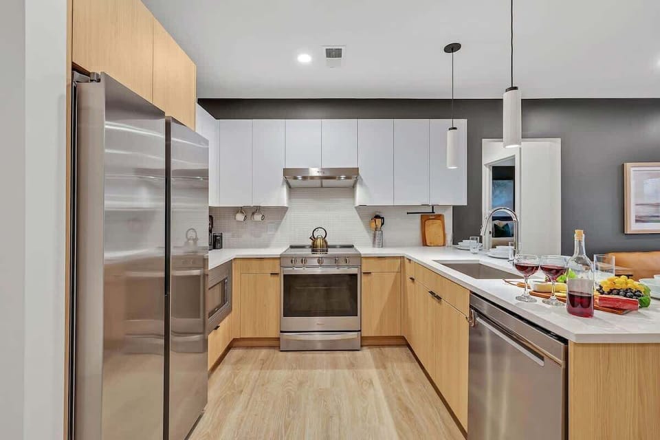 Fully equipped modern kitchen stocked with all culinary essentials and featuring brand new stainless steel appliances with bar seating.