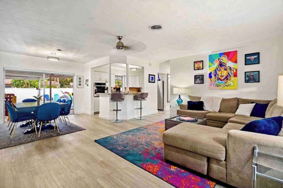 - Bright open living space with sectional sofa and colorful decor  
- Modern kitchen with bar seating and stainless steel appliances  
- Spacious layout designed for comfort and style
