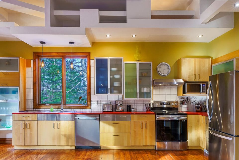 Cuisine complète avec électroménagers modernes et grand plan de travail, idéale pour cuisiner entre amis.