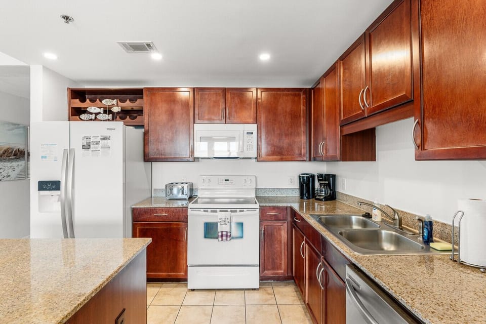 Fully equipped kitchen with modern appliances, granite countertops, and ample cabinet space for a convenient cooking experience