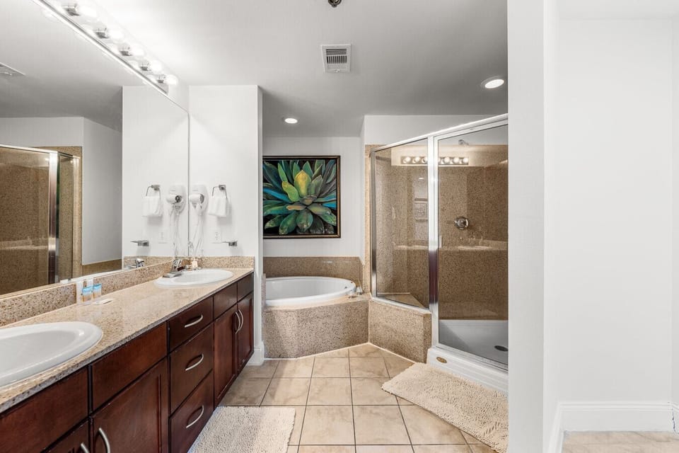 Spacious master bathroom featuring a soaking tub, a separate glass-enclosed shower, and granite accents for a relaxing retreat.
