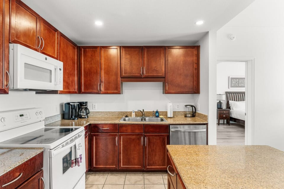 Fully equipped kitchen with modern appliances, granite countertops, and ample cabinet space for a convenient cooking experience