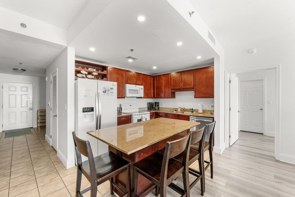 Spacious kitchen and dining area featuring a granite island with seating, modern appliances, and an open layout
