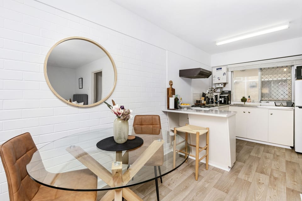 Imagine yourself enjoying a meal at this charming dining table, surrounded by warm lighting and a stylish kitchen.