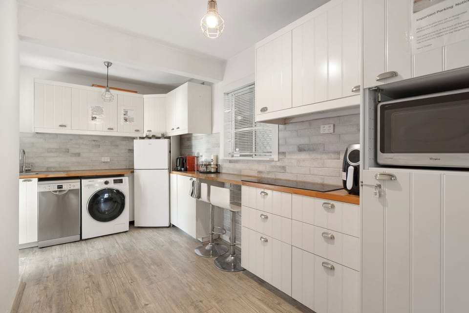 Bright and functional, with classic white cabinets, warm wood accents, and modern appliances.