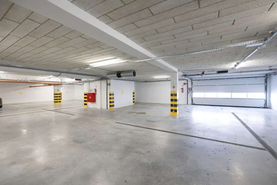 A clean and spacious underground parking garage with ample lighting and marked spaces.


