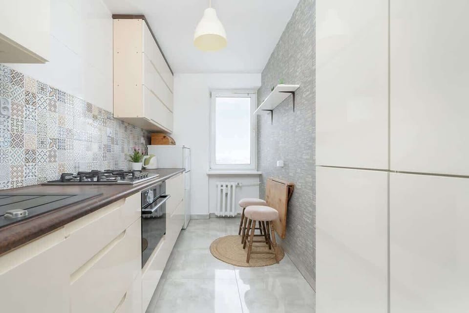 Another angle of the kitchen showcasing a gas stove, white cabinetry, and a minimalist layout, enhancing the cooking space.
