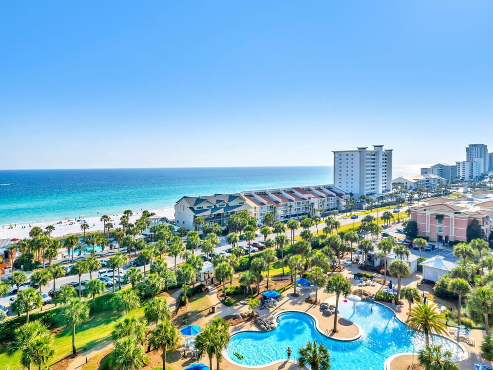 Stunning beachfront resort featuring multiple pools, palm trees, and pristine white sand beach with crystal-clear turquoise waters.