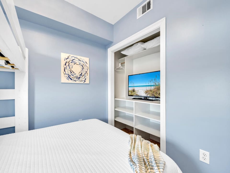 Unwind in your serene blue bedroom with built-in storage and entertainment center, perfect for peaceful evenings.