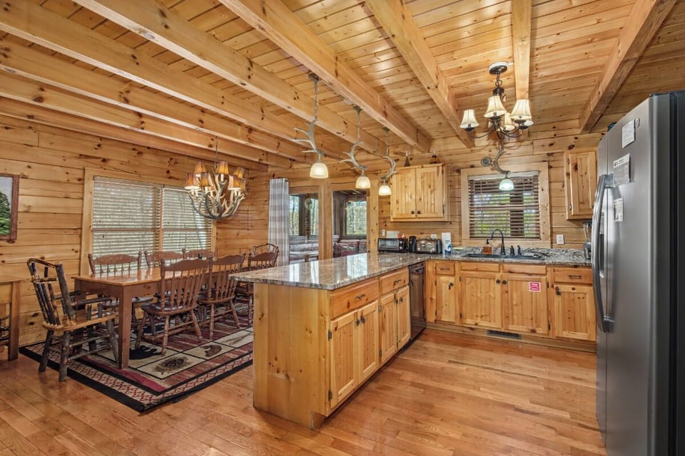 Step into your rustic kitchen where warm wood surrounds you, granite counters invite meal prep, and the open design connects cooking with conversation.
