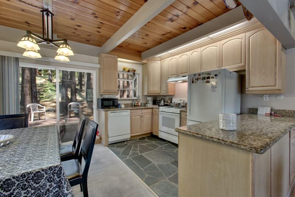 Fully equipped kitchen with granite countertops, modern appliances, and a spacious layout.