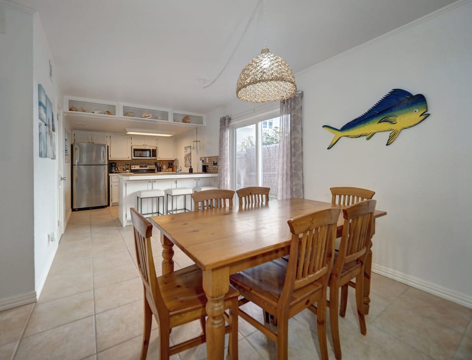 The living room leads into the dining area with table seating for six.