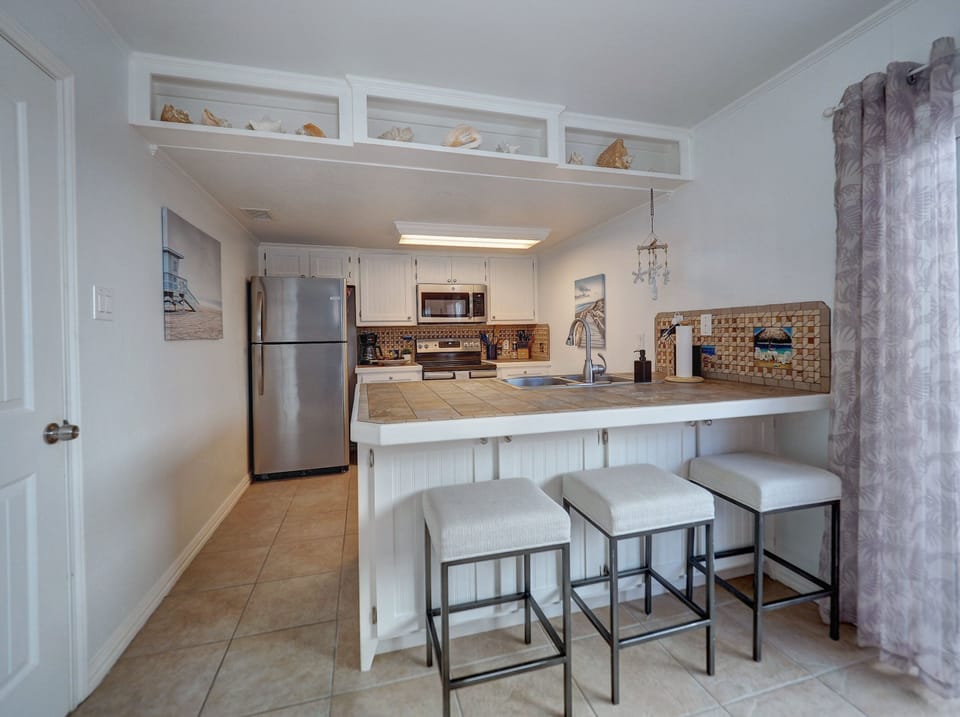 There's a kitchen breakfast bar with cushy seating for three.