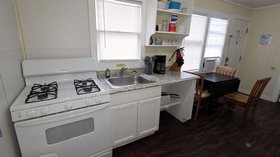The kitchen has a gas range and basic kitchen supplies.
