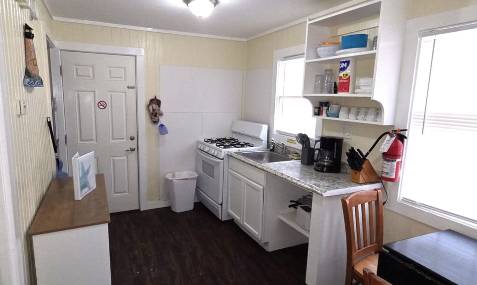The main room has a full kitchen and small dining area.