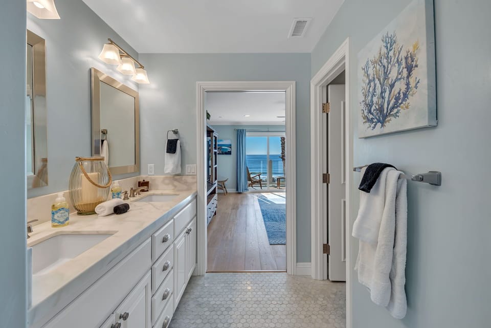 Refresh in the spacious primary ensuite featuring two vanities, a walk-in shower, separate bathtub, toilet, and walk-in closet, with direct access to the back balcony with seating.