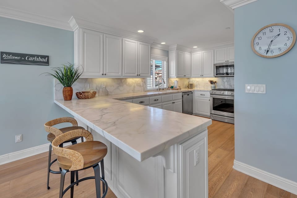 Cook and dine in a modern, fully-equipped kitchen featuring bar stool seating for two—perfect for casual meals, snacks, or morning coffee.