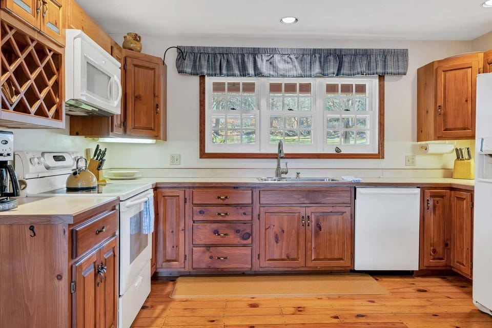 Country kitchen with pine cabinetry, wine rack, and all essentials