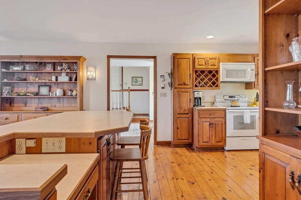 Kitchen with breakfast bar seating, wine rack, and open layout to dining