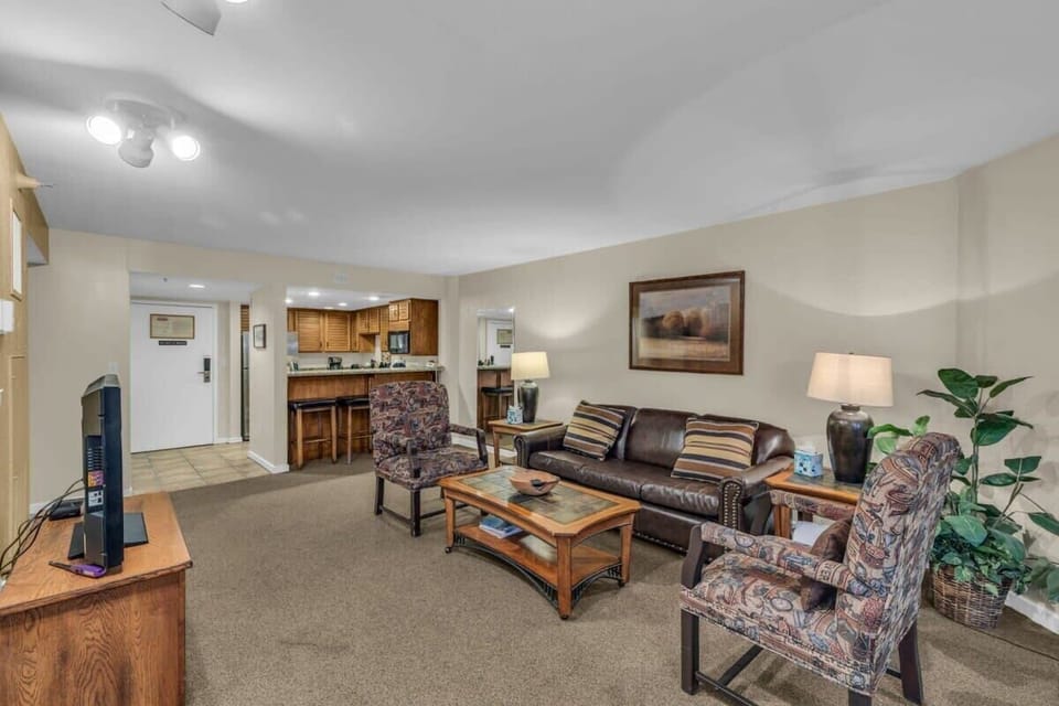 The living room is a cozy space that offers an inviting and homey common area for relaxing with ample seating, a fireplace, and a TV.