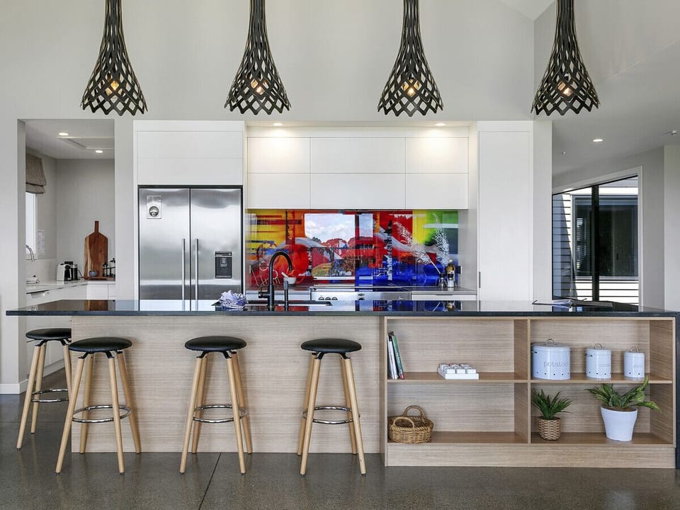 A generously designed open-plan kitchen, elegantly equipped with an oven, fridge/freezer, dishwasher, and a complete set of kitchen utensils and cutlery.