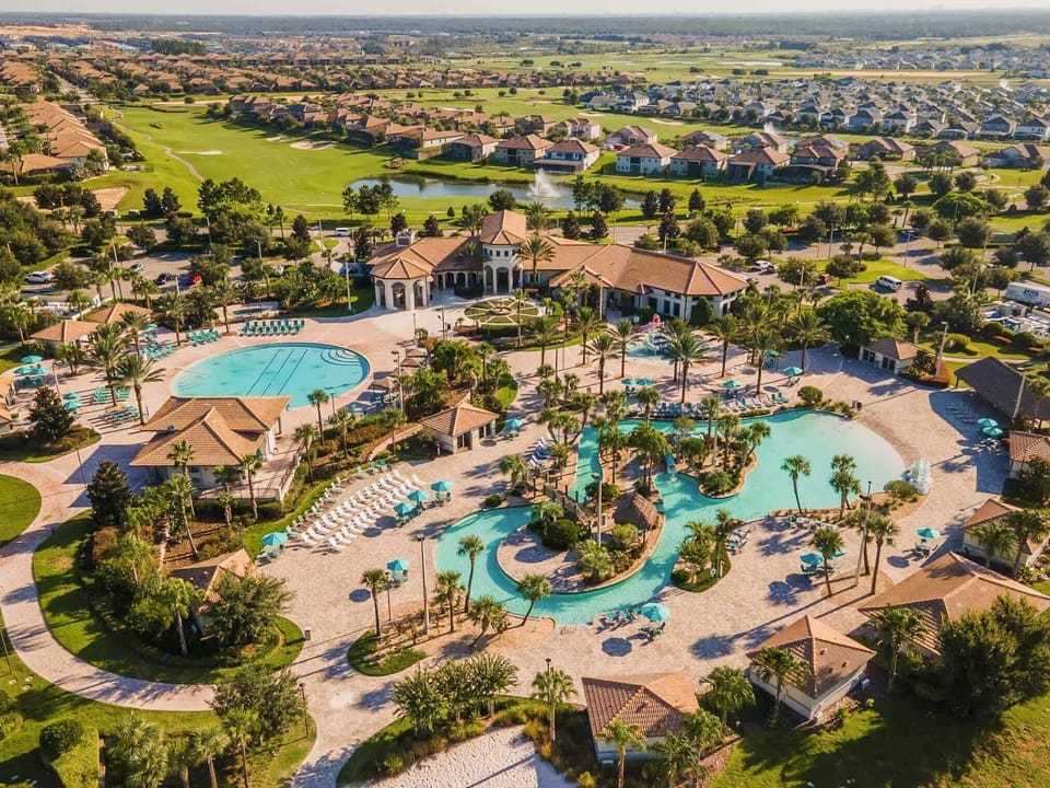 Aerial view showcasing a large pool area surrounded by lush landscaping.