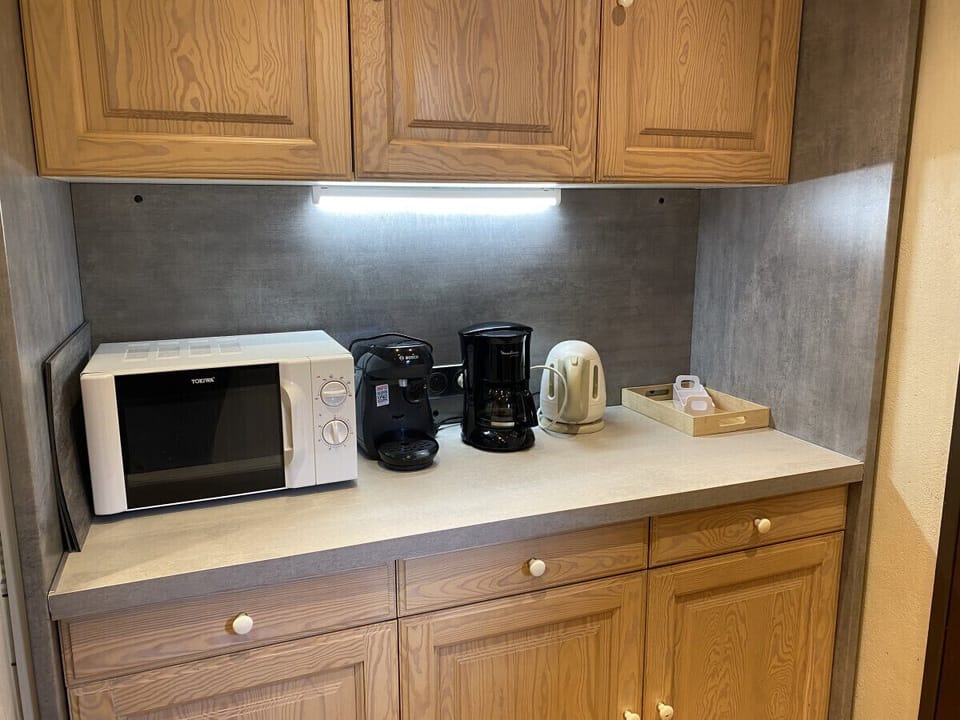 Kitchen with fridge, stove, microwave, coffee maker, kettle, dishwasher