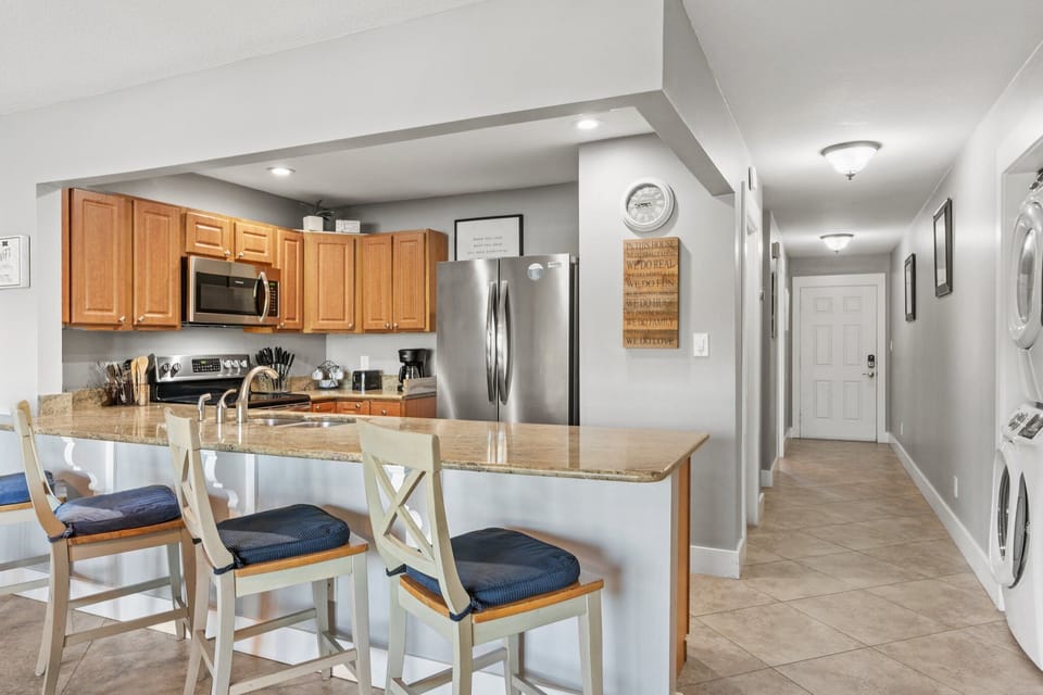 Spacious kitchen with stainless appliances, granite countertops, and bar seating—perfect for meals, snacks, and gathering together.