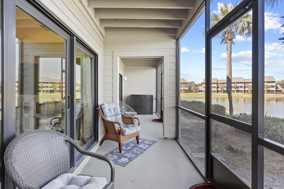 Spacious screened patio with comfortable seating and peaceful golf course and lake views.