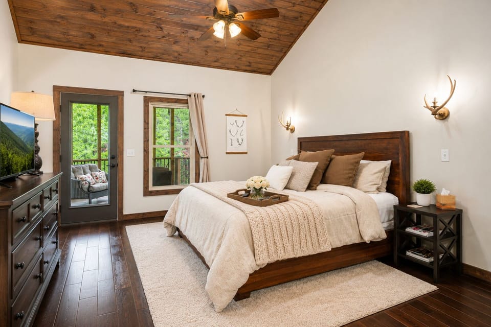Master bedroom w/ king bed, vaulted wood ceiling, smart TV, and door to screened in porch