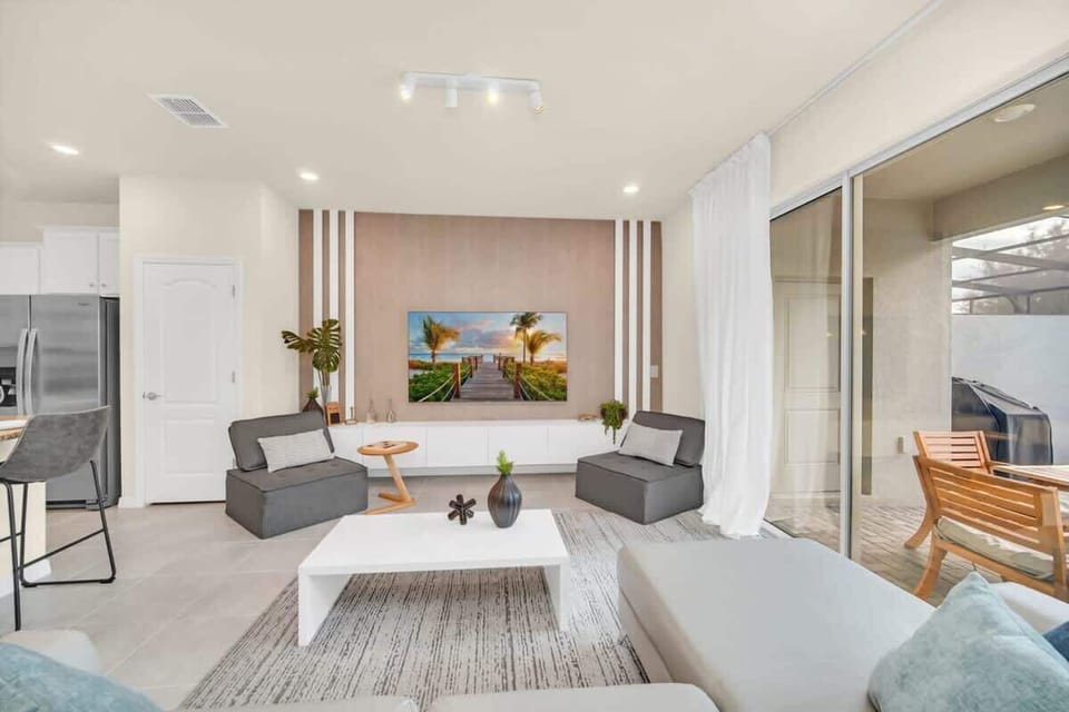 Modern living room with comfortable seating and a large sliding glass door leading to an outdoor patio.