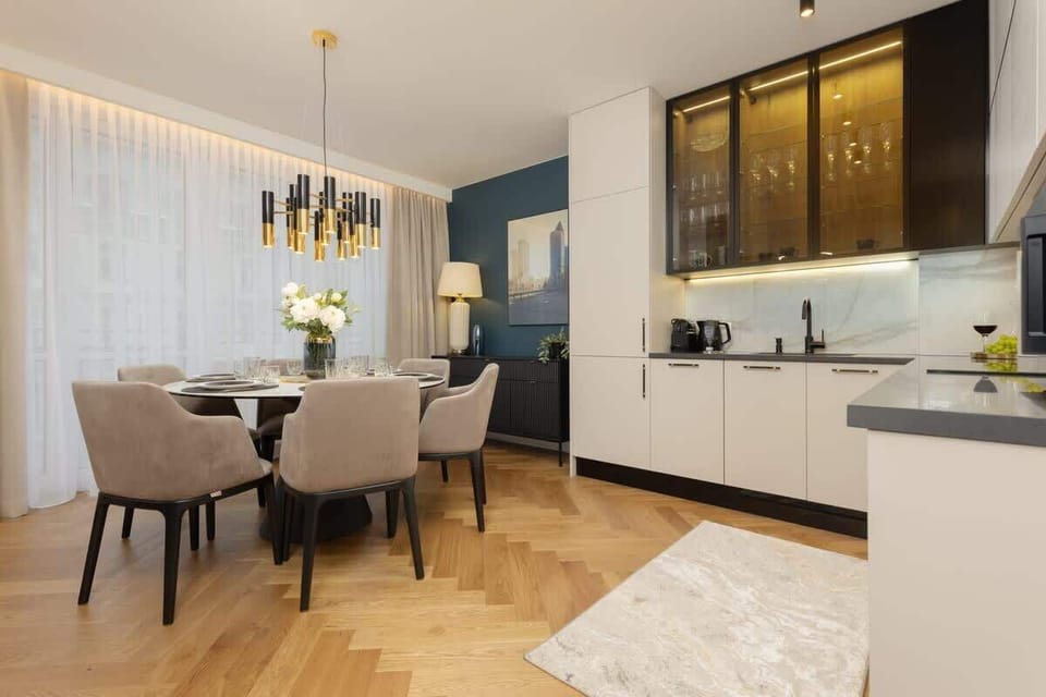 Dining area featuring a rectangular table, upholstered chairs, an eye-catching chandelier, and soft curtains.
