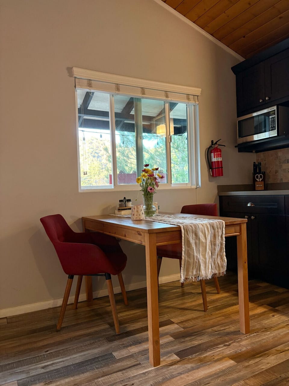 A cheerful dining nook with colorful blooms and sunlight through the window, perfect for enjoying a relaxed start or winding down the day.
