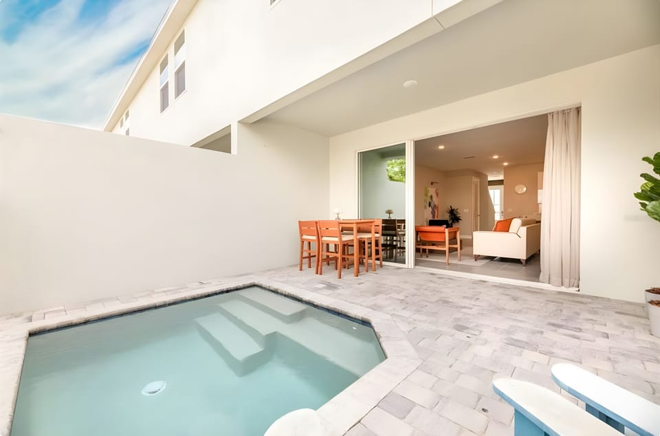 Step into your private oasis, featuring a charming plunge pool surrounded by elegant stone pavers. The open layout seamlessly connects to a cozy dining area, enhanced by natural light streaming through large sliding doors.