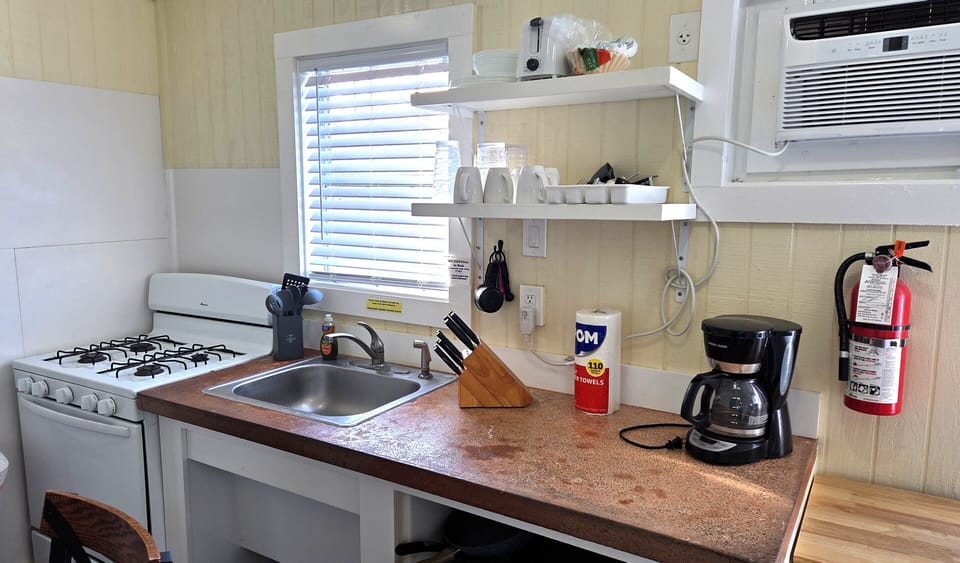 The kitchen includes a refrigerator, stove, microwave, coffee maker, and basics