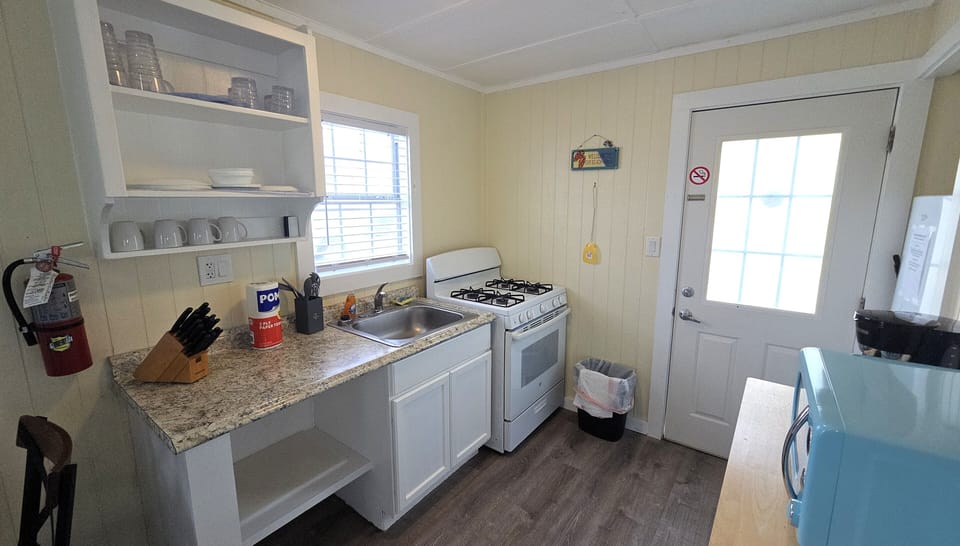 The cottage has a full kitchen with a refrigerator, microwave, and gas stove