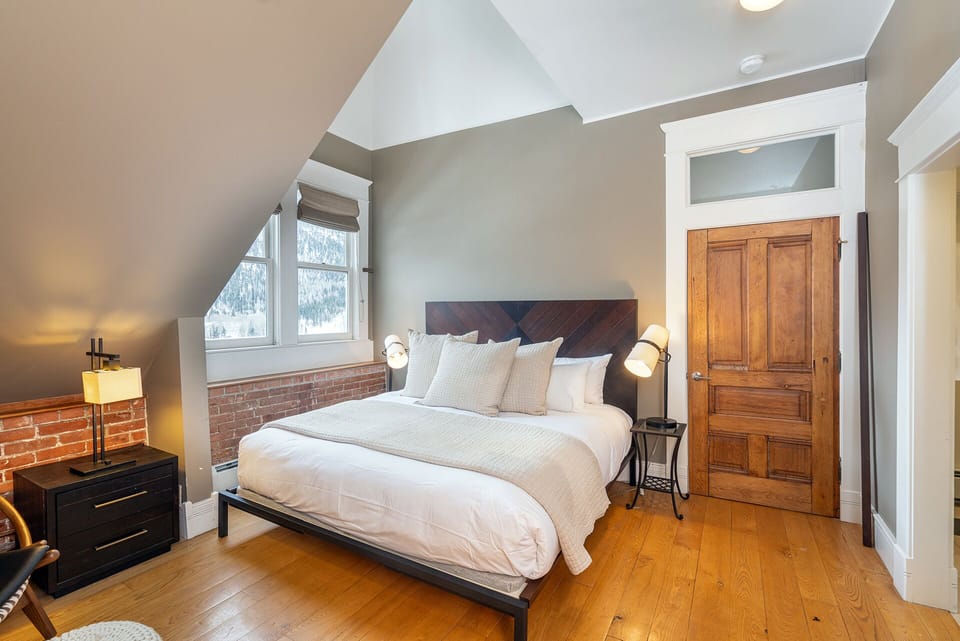 King bedroom with ensuite bath, inviting comfort, and light-filled windows.