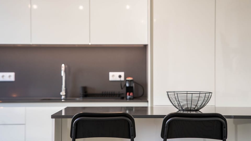 Gather around the stylish kitchen island for a casual breakfast or a quick snack, enjoying the modern ambiance created by the sleek design and thoughtful lighting. This spot is perfect for socializing or simply enjoying a meal.
