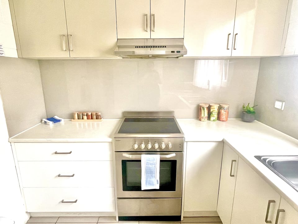 Fully equipped kitchen with fridge, electric stove and dishwasher.