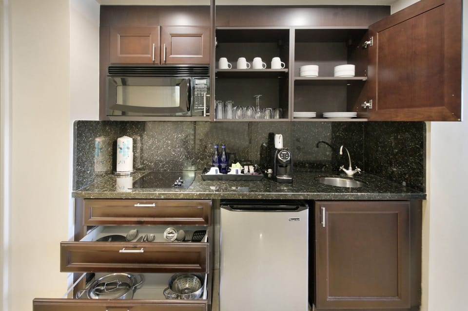 Kitchen equipped with dishes, glasses, pots & pans, flatware & utensils