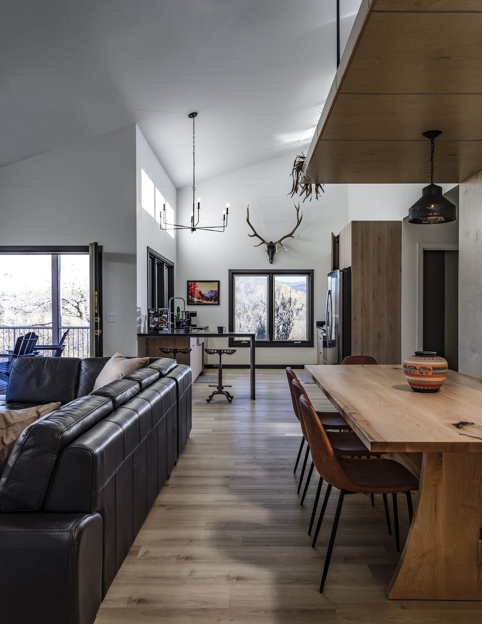 Gather around our Canary Workshop farm table in the dining area, surrounded by curated local art, offering a cultural feast with stunning views of Oak Creek and the property.
