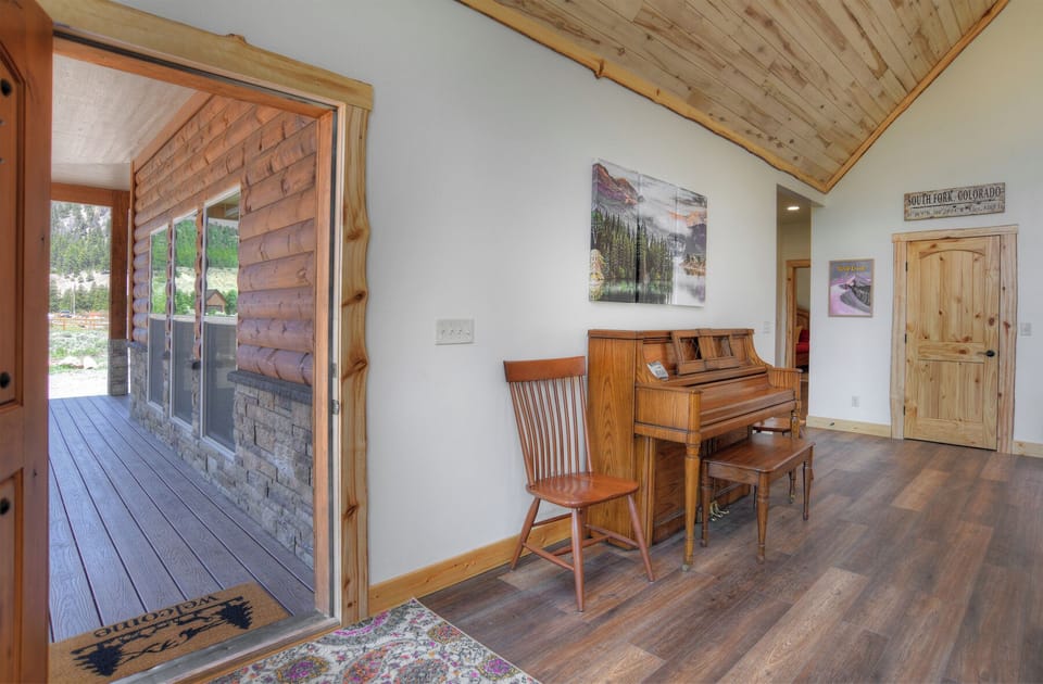 Living room - Mountain Aire VRC Rental Home - Our living room with piano.  Front door leads to covered porch.